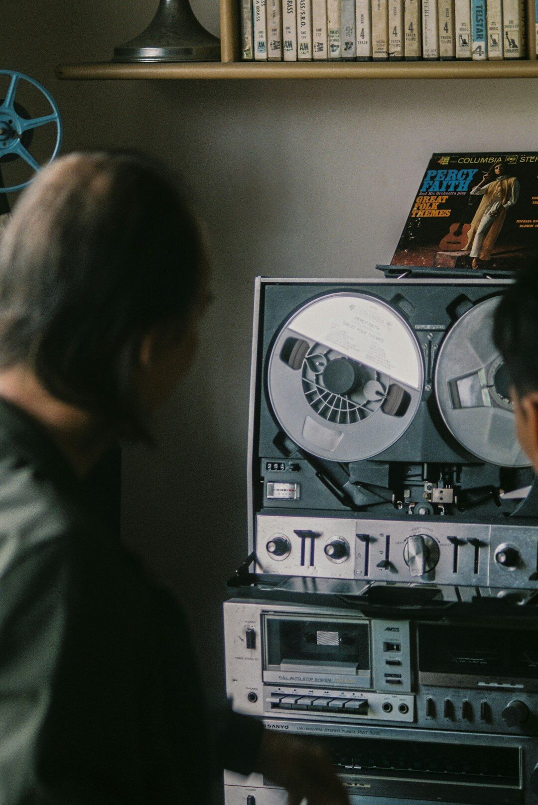 Film editor working at a vintage editing suite with monitors and tape reels